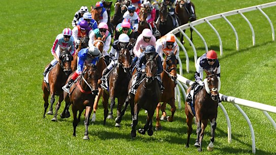 MELBOURNE, AUSTRALIA - NOVEMBER 03: Jye McNeil riding Twilight Payment leads the field around the first bend in the Lexus Melbourne Cup during 2020 Lexus Melbourne Cup Day at Flemington Racecourse on November 03, 2020 in Melbourne, Australia. (Photo by Quinn Rooney/Getty Images for the VRC)