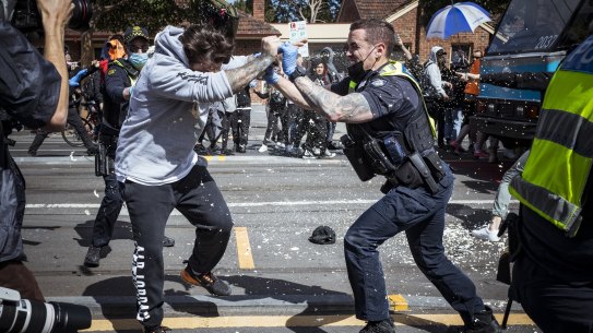 A police officer uses capsicum spray on a protester during Melbourne’s anti-lockdown rally. 