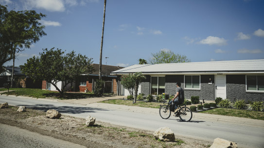 A man rides a bike down Memes Street, in the proposed city of Starbase, Texas.