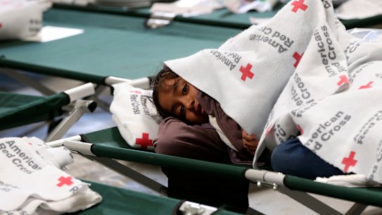 A young girl keeps warm under her blanket at the new Casa del Refugiado in east El Paso, Texas.