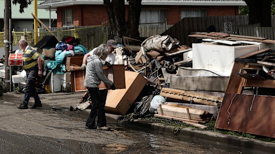People clean out flood-damaged belongings in Maribyrnong on Sunday.