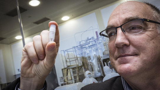 Dr Andrew Nash with a replica vial of the vaccine.