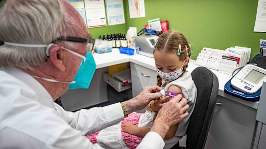 Emily Hyslop, 8, received her COVID-19 vaccine from pharmacist Alan Martin at Penrith on Monday.