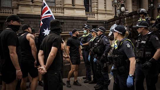 Members of a neo-Nazi group square off against police at an anti-trans rights rally outside Victoria’s parliament in March.