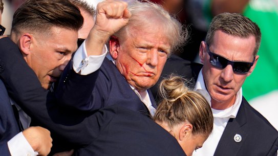 Donald Trump is helped off stage after assassination attempt.