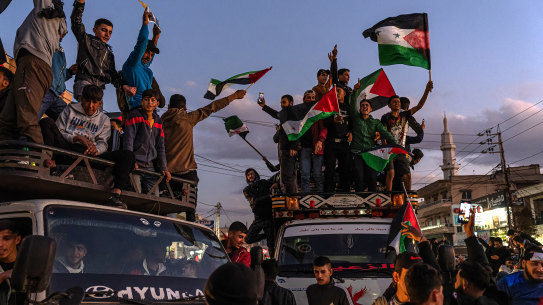 People celebrate while waving Syrian flags while stuck in traffic leading up to the Lebanon Syria Maasna border crossing in Bar Elias, Lebanon.