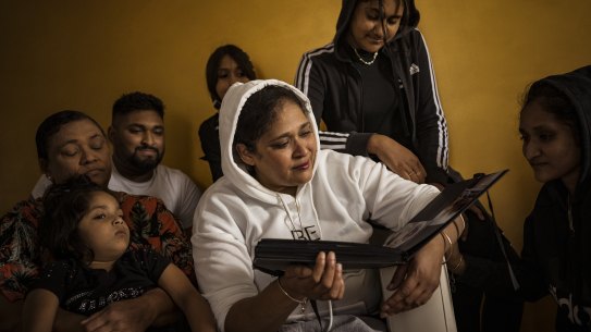 Jasmin Hussein weeps as she and her family (Eiliya, Grandma Rita, Zaahir, Imani, Aleena and Ammara) look through a photo album containing photographs of her deceased 14-year-old daughter Alysha.