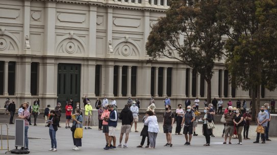 04/01/22 Long lines snake around the Royal Exhibition Building in Carlton as people queue to get their Covid-19 booster shot. Photograph by Chris Hopkins