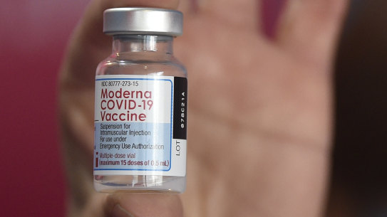 A health worker shows a vial of the Moderna vaccine for COVID-19.