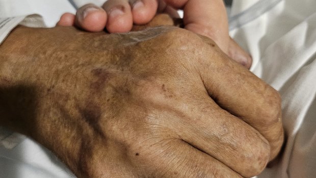 Naureen Choudhry and her father Jamil Choudhry hold hands.