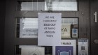 A sign posted to the door of a pharmacy in Melbourne informs customers it has sold out of rapid antigen tests.