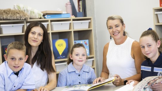 Renae Gentile, principal of Mary Queen of Heaven primary school (in white), with deputy principal Daniela De Luca and students (L-R) Adam, 9, Livinia, 6, and Amelia, 10. 


