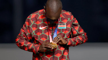 Eliud Kipchoge of Team Kenya checks out his gold during the medal ceremony for the men’s marathon.