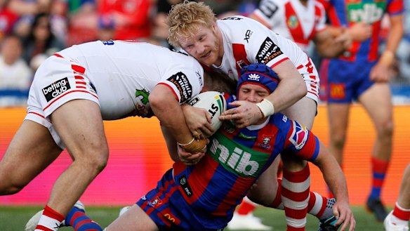 Combative character: James Graham tackles Jamie Buhrer of the Knights at McDonald Jones Stadium.