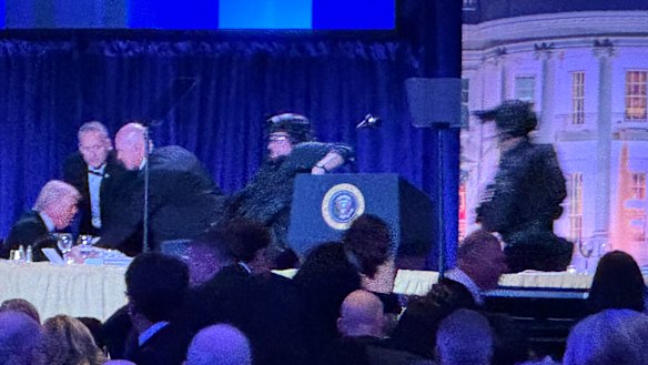 O presidente dos EUA, Donald Trump, antes de ser retirado do palco.