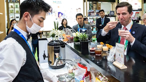 Trade Minister Simon Birmingham trying vitamin drinks at the Swisse stand on day one of the China International Import Expo in Shanghai this week.