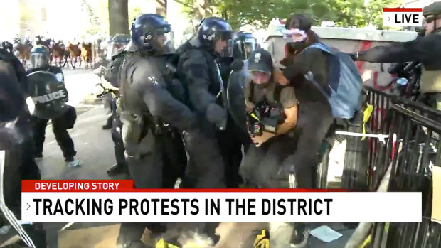 A screen-capture taken from video shows Network Seven cameraman Tim Myers and reporter Amelia Brace as they were assaulted by police officers while covering protests outside the White House.