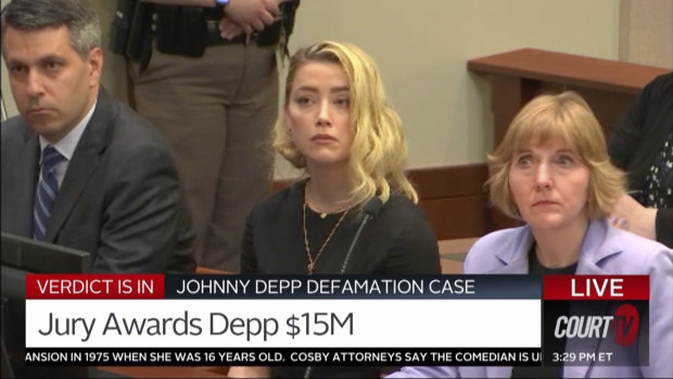 In this screen grab from video, Amber Heard, centre, and her lawyers Elaine Bredehoft, right, and Ben Rottenborn, left, react as the verdict is read.