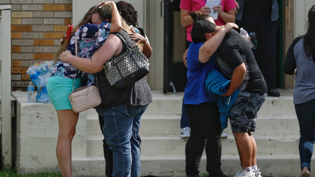 Parents and students embrace outside a gym where students had waited to be reunited with their families.