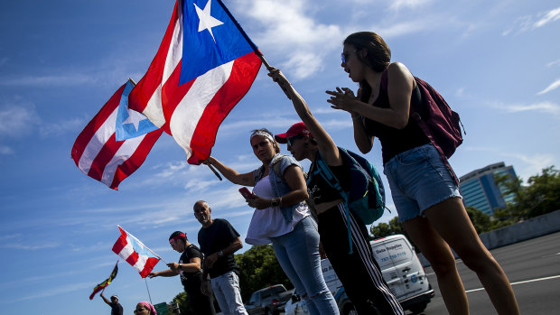 Demonstrators wave Puerto Rican flags during a protest in San Juan, Puerto Rico.