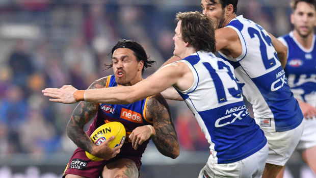 Lion Allen Christensen is tackled by Jared Polec at the Gabba on Saturday.