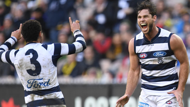 Tom Hawkins (right) after booting a goal for the Cats.