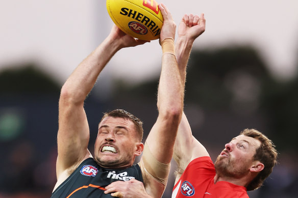 Kieren Briggs of the Giants is challenged by Harry Cunningham of the Swans.