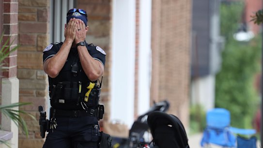 A Lake County police officer walks down Central Ave in Highland Park after the shooting.