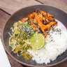 Korean chicken is bathed in a glistening glaze of gochujang-based sauce.