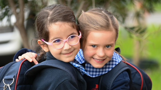 Brunswick prep students Eleni (left) and Zara embrace as they return to school on Monday morning after 74 days of remote learning.