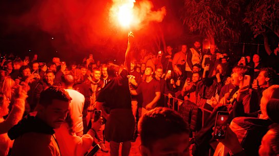 A soccer fan lets off a flare at Melbourne’s Federation Square during the Socceroos’ World Cup match.