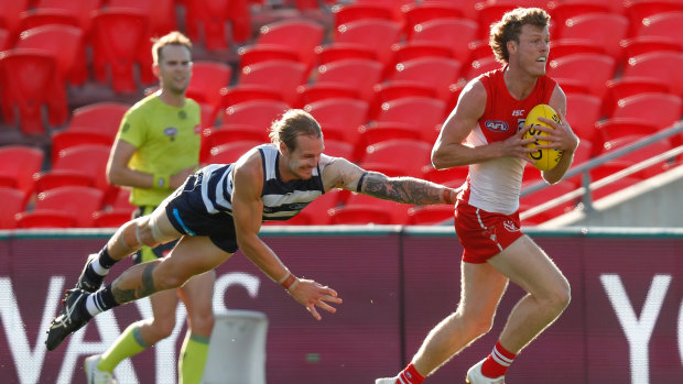 Full flight: Geelong's Tom Stewart launches into a tackle on Sydney's Nick Blakey.