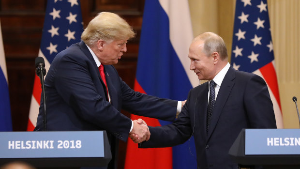 U.S. President Donald Trump, left, shakes hands with Vladimir Putin