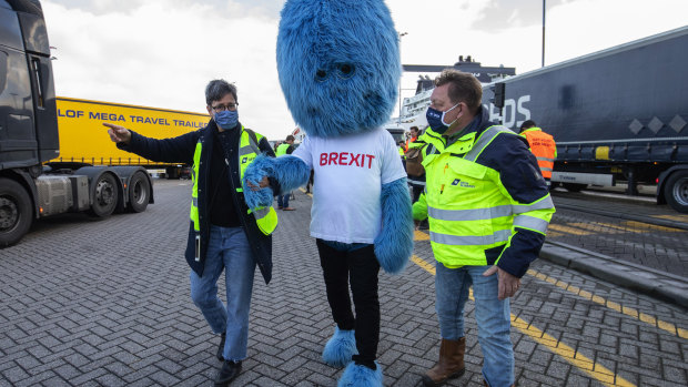 Port workers walk with a 'Brexit monster' near haulage trucks at the DFDS Ferry Terminal in Rotterdam, Netherlands on Tuesday.