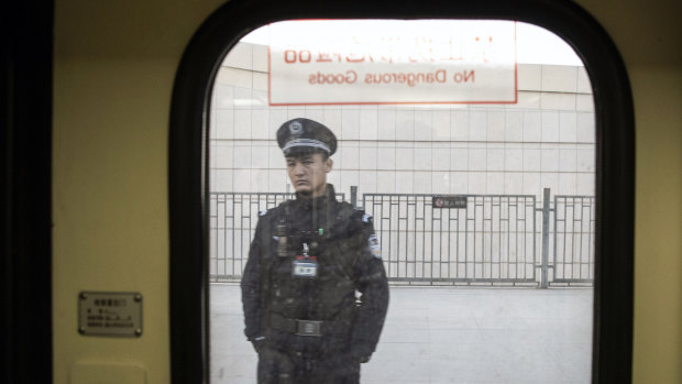 A police officer is seen through a train window in Turpan, Xinjiang, last year.
