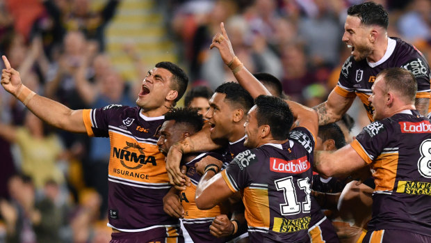 Wild Broncos: Brisbane celebrate James Segeyaro's try and victory over the Roosters on Friday night.