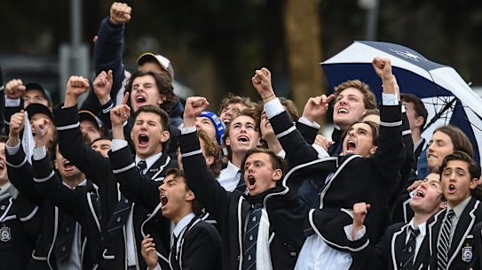 School ties: Caulfield Grammar students cheer a goal against Carey Grammar in the APS grand final.