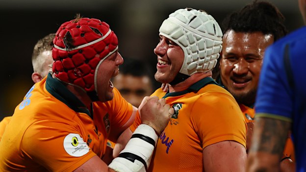 Josh Canham is mobbed after scoring a hat-trick against Italy in Perth.