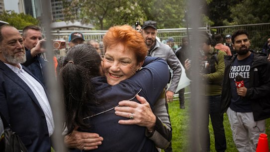 A líder de uma nação, Pauline Hanson, abraça um apoiador antes de se dirigir à multidão no comício Put Australia First em Flagstaff Gardens, em Melbourne, em novembro de 2025.
