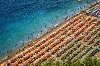 Foto aerea di turisti che giocano e prendono il sole su una spiaggia sabbiosa a Positano, Italia.