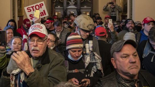 Rioters walk through the doors of the US Capitol building as Congress was meeting to certify the election results.
