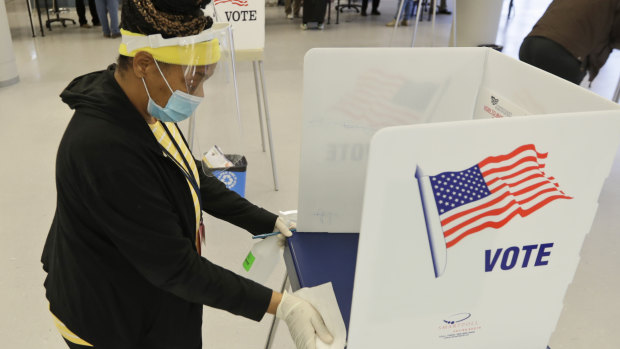 A worker cleans an election booth after a person voted at the Cuyahoga County Board of Elections in Cleveland. 