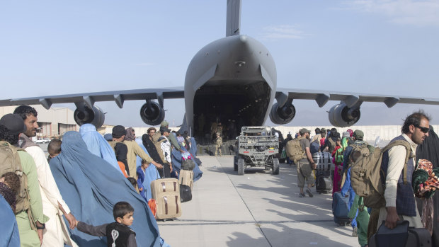 People wait in line to board a US Air Force plane in Kabul. 