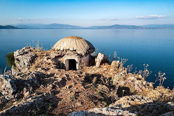 A mushroom-shaped bunker on the rocky shore of Lake Ohrid, Albania.