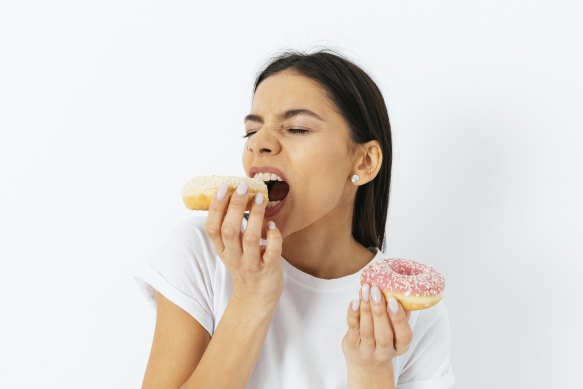 There are mindfulness techniques to acknowledge and become more aware of your cravings and wait them out, rather than trying to ignore them.

Portrait hungry young woman craving eating donuts isolated over white background.