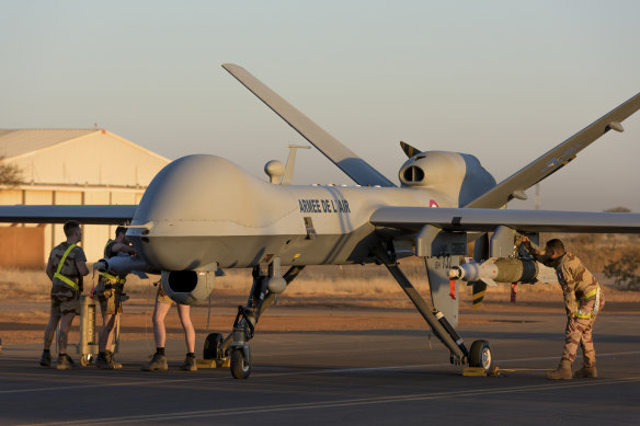 French soldiers loading a French Reaper drone with two GBU 12 missiles on Niamey airbase, Niger.