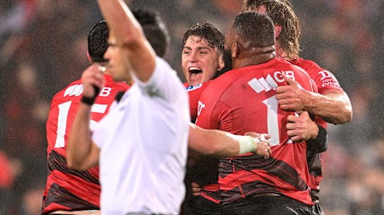 James O’Connor is swamped by Crusaders teammates after his winning kick.