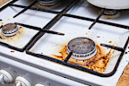 a very dirty gas stove with grease and carbon deposits due to long-term use