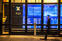 A man in corporate suit walked past ASX (Australian Stock Exchange)