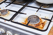 a very dirty gas stove with grease and carbon deposits due to long-term use